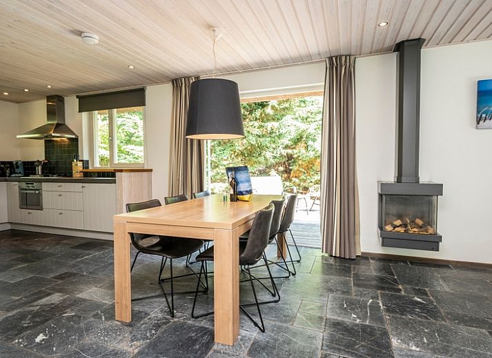 Bright living room of Westenwind vacation home in De Koog, Texel with comfortable seating area and view of the terrace.