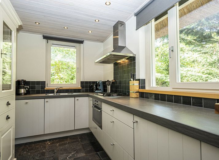Bright living room of Westenwind vacation home in De Koog, Texel with comfortable seating area and view of the terrace.