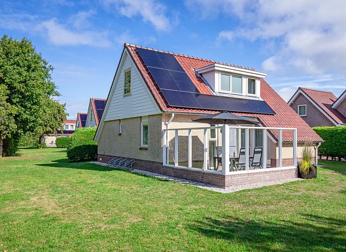 Villa 7 vacation home in De Koog Texel with spacious garden and terrace under a blue sky.
