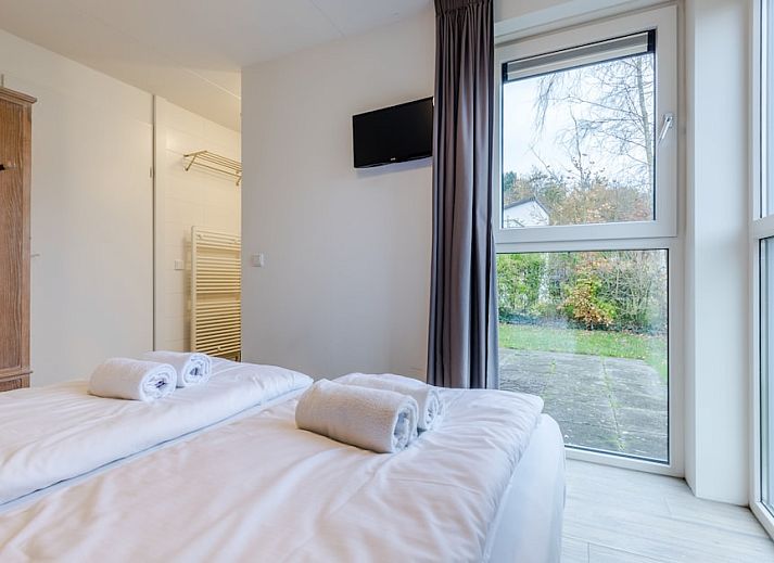 Modernes Badezimmer in Schilpbanck 4, einem komfortablen Bungalow in De Koog, Texel, mit glatten weissen Fliesen und einer geraeumigen Dusche.