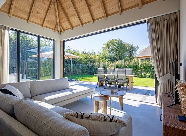 Veranda of Villa Jolie in De Koog, Texel, Wadden Islands, with comfortable seating and garden views.