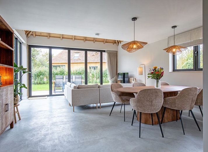 Veranda of Villa Jolie in De Koog, Texel, Wadden Islands, with comfortable seating and garden views.