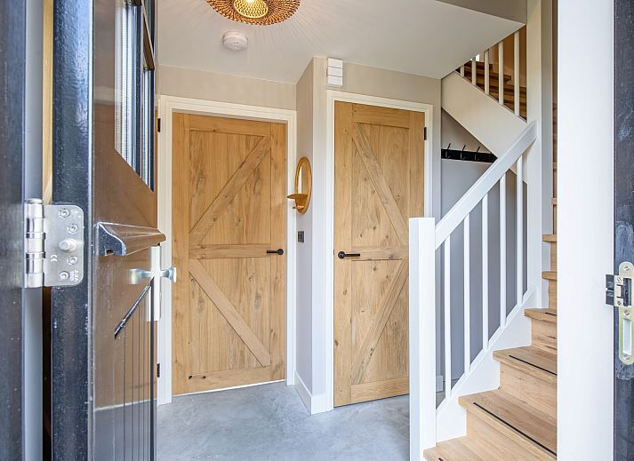 Stylish interior of Villa Jolie vacation home in De Koog, Texel, with modern decor and wooden accents.