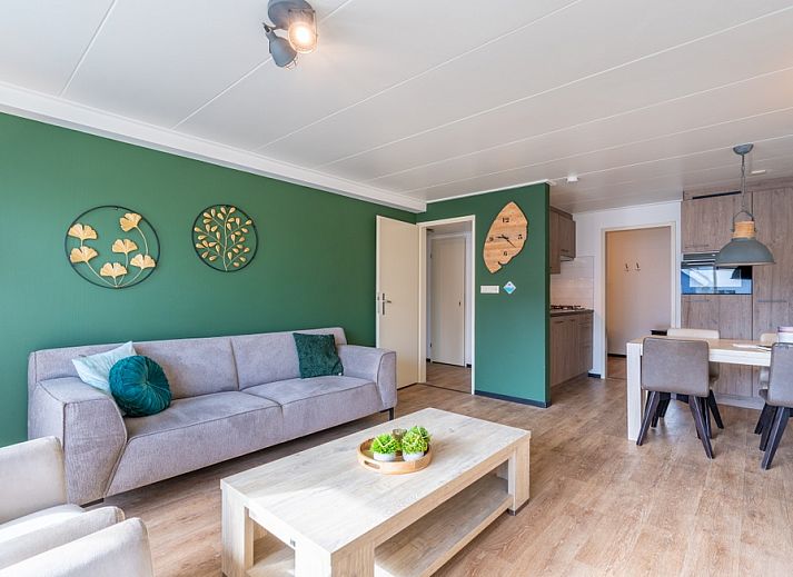 Stilvolles Wohnzimmer des Appartements Anna 218 in De Koog, Texel, mit gruenen Akzenten und gemuetlicher Sitzecke.
