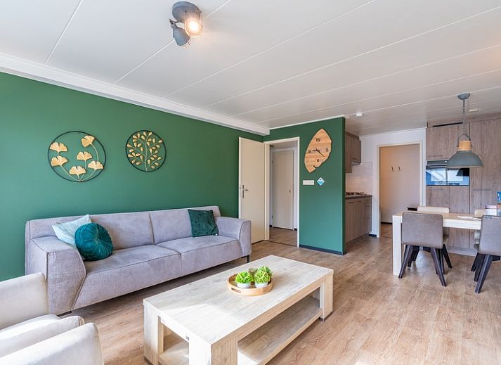 Stilvolles Wohnzimmer des Appartements Anna 218 in De Koog, Texel, mit gruenen Akzenten und gemuetlicher Sitzecke.