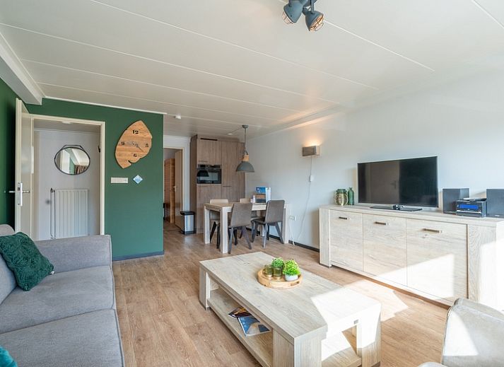 Stilvolles Wohnzimmer des Appartements Anna 218 in De Koog, Texel, mit gruenen Akzenten und gemuetlicher Sitzecke.