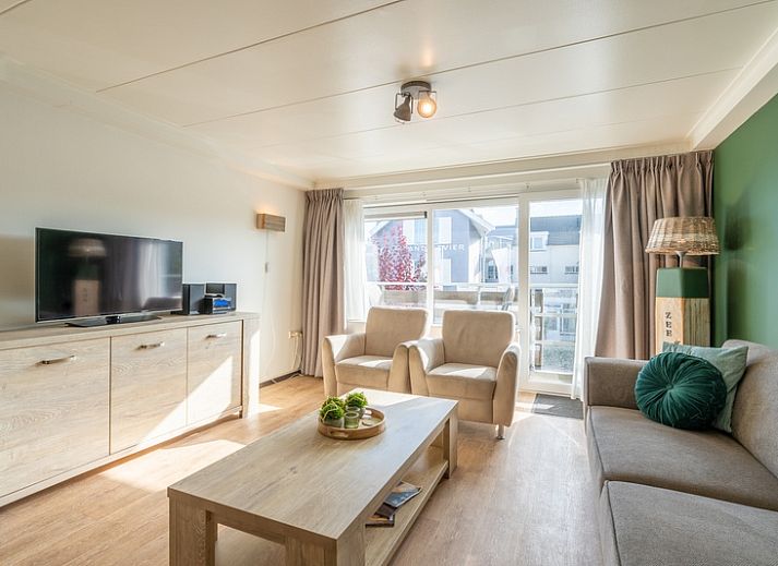 Stilvolles Wohnzimmer des Appartements Anna 218 in De Koog, Texel, mit gruenen Akzenten und gemuetlicher Sitzecke.