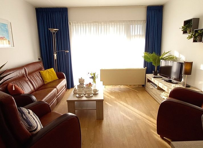 Eingang zu De Pelikaan Apartments, De Koog, Texel, umgeben von Gruenpflanzen und einem einladenden Eingang.