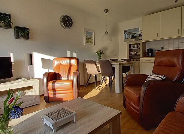 Eingang zu De Pelikaan Apartments, De Koog, Texel, umgeben von Gruenpflanzen und einem einladenden Eingang.