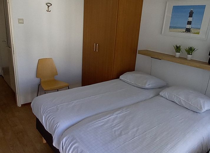 Eingang zu De Pelikaan Apartments, De Koog, Texel, umgeben von Gruenpflanzen und einem einladenden Eingang.