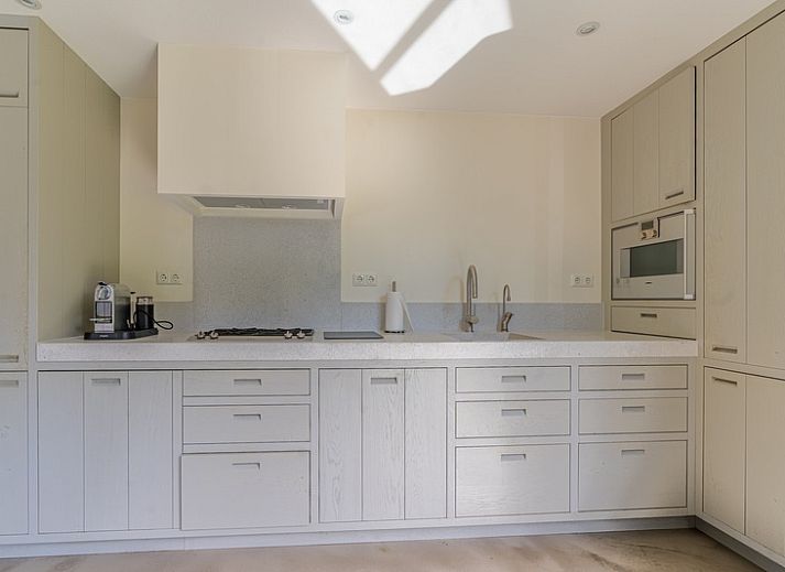 Bright interior space of Duynzoom Villa 5 in De Koog, Texel, overlooking the terrace and green surroundings.