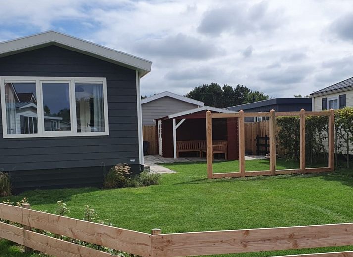 Chaletpark Bregkoog, De Koog, Texel: Modern chalet with green garden and wooden fence.