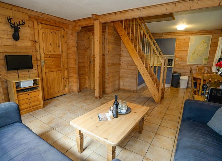 Charmantes Ferienhaus mit roter Fassade im Ferienpark Het Oude Dijkje, De Koog, Texel, umgeben von viel Gruen.