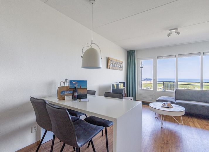 Helles Wohnzimmer im Appartement Juliana 102 Zeezicht, De Koog, Texel mit gemuetlicher Sitzecke und Meerblick.