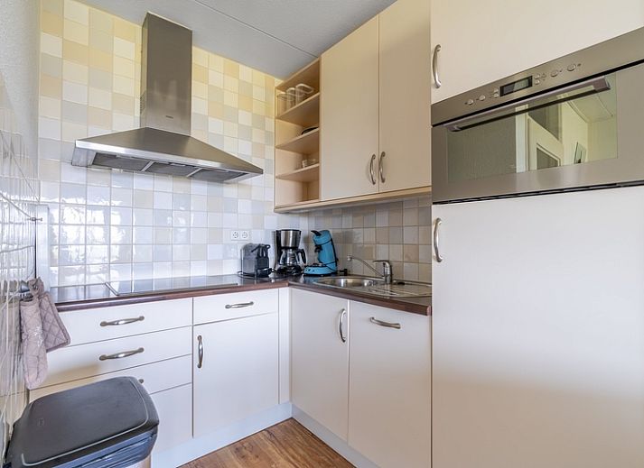 Helles Wohnzimmer im Appartement Juliana 102 Zeezicht, De Koog, Texel mit gemuetlicher Sitzecke und Meerblick.