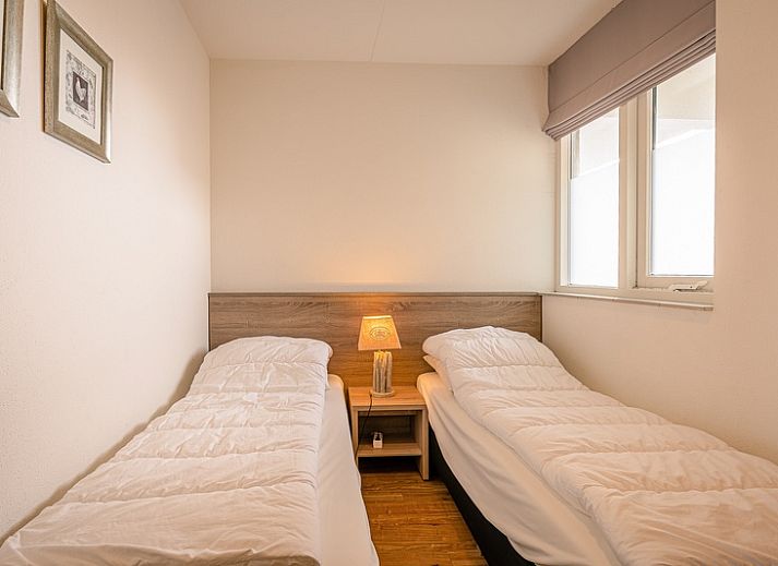 Helles Wohnzimmer im Appartement Juliana 102 Zeezicht, De Koog, Texel mit gemuetlicher Sitzecke und Meerblick.