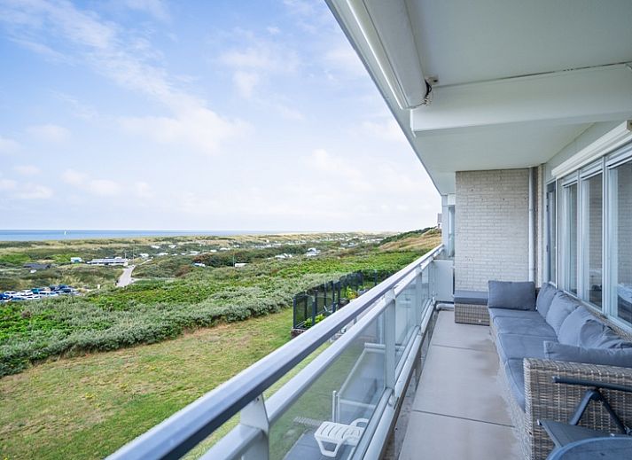 Geraeumiges Wohnzimmer des Appartements Juliana 102 Zeezicht, De Koog, Texel mit moderner Einrichtung und Meerblick.