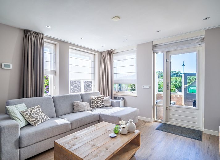 Cozy living room in Apartment Juliana 034 Eilandzicht, De Koog, Texel with comfortable sofa and garden view.