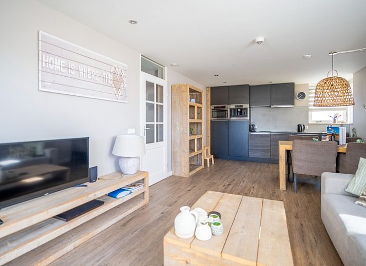 Cozy living room in Apartment Juliana 034 Eilandzicht, De Koog, Texel with comfortable sofa and garden view.