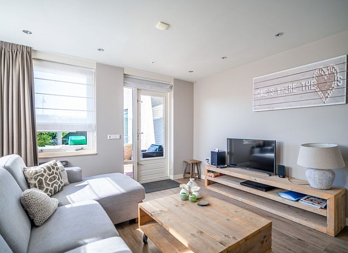 Cozy living room in Apartment Juliana 034 Eilandzicht, De Koog, Texel with comfortable sofa and garden view.