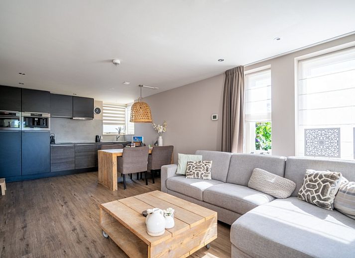 Cozy living room in Apartment Juliana 034 Eilandzicht, De Koog, Texel with comfortable sofa and garden view.