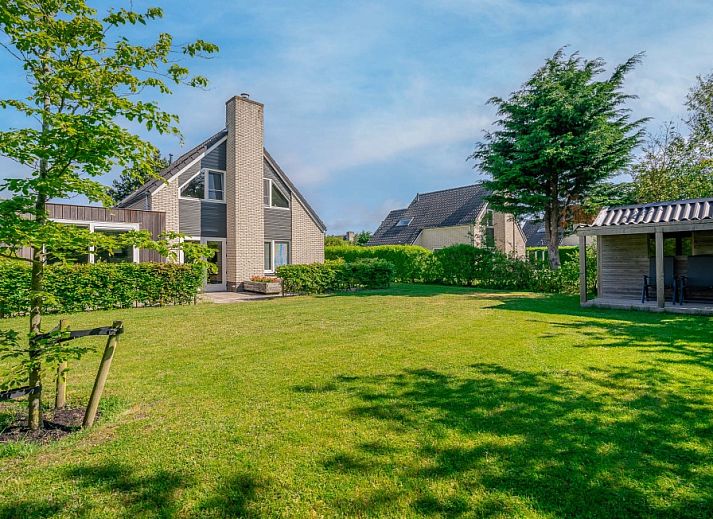 Vacation home Honeysuckle 93 with sauna in De Koog, Texel, surrounded by green garden and terrace.
