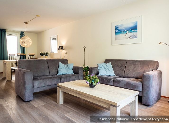 Gemuetliches Wohnzimmer im Ferienhaus Typ 5A, De Koog, Texel, mit bequemen Sofas und dekorativen Kunstwerken.