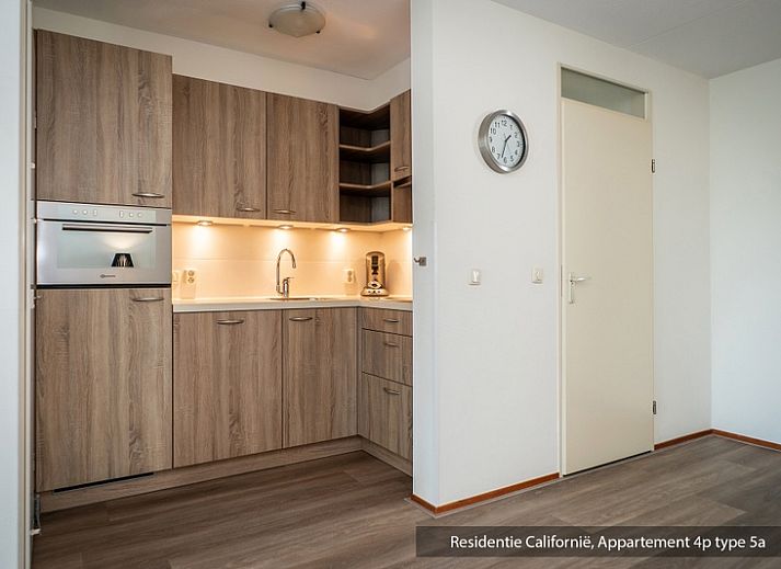 Stilvolle Sitzecke im Ferienhaus Typ 5A, De Koog, Texel, mit weichen Sofas und Couchtisch aus Holz.