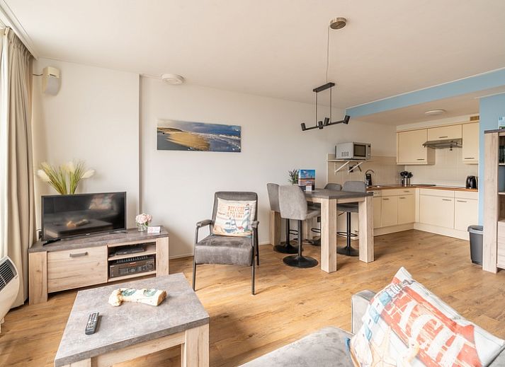 Gemuetliches Wohnzimmer des Appartements Juliana 076 Eilandzicht in De Koog, Texel mit Blick auf die Terrasse und viel Tageslicht.