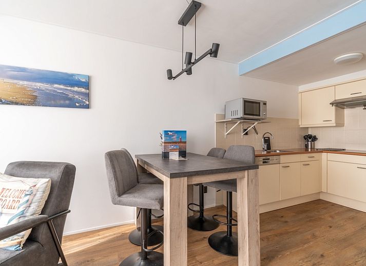 Helles Wohnzimmer des Appartements Juliana 076 Eilandzicht in De Koog, Texel, mit bequemen Sitzmoebeln und moderner Einrichtung.