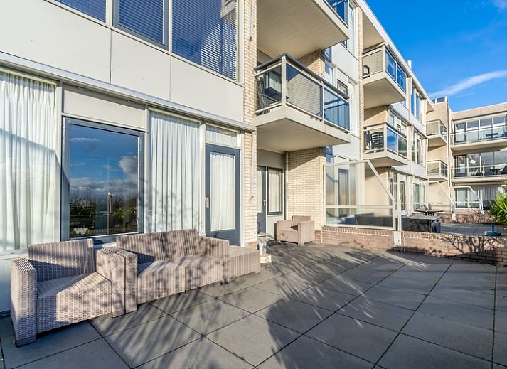 Helles Wohnzimmer des Appartements Juliana 076 Eilandzicht in De Koog, Texel, mit bequemen Sitzmoebeln und moderner Einrichtung.