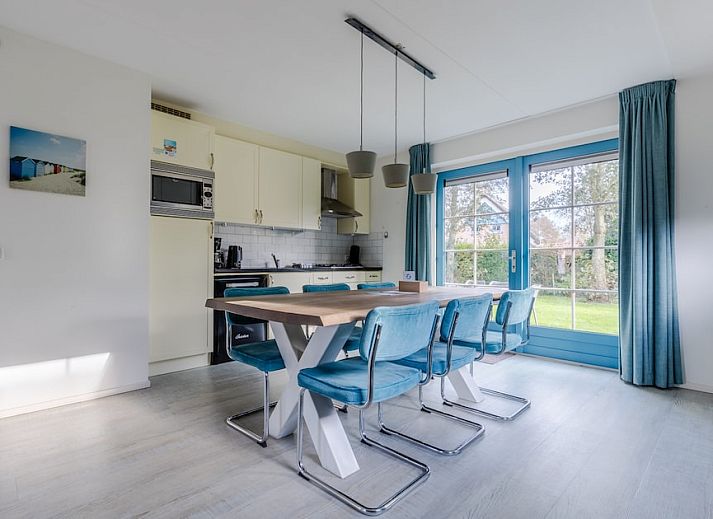 Charmante bungalow T6AB met rieten dak in De Koog, Texel, omgeven door groene tuin en rustgevende natuur op de Waddeneilanden.