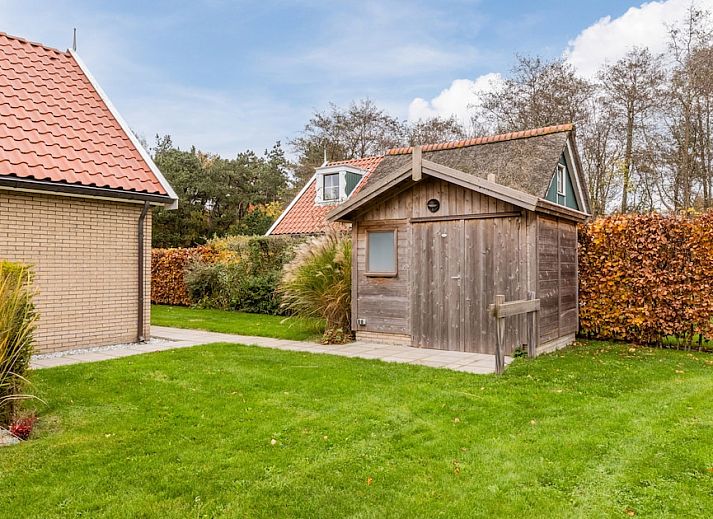 T6B Komfort-Bungalow in De Koog, Texel mit Reetdach und gemuetlicher Veranda, umgeben von Herbstfarben.