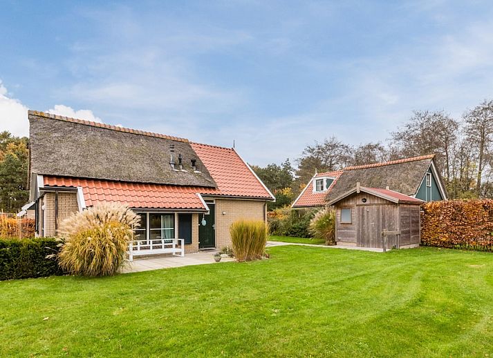 T6B Komfort-Bungalow in De Koog, Texel mit Reetdach und gemuetlicher Veranda, umgeben von Herbstfarben.