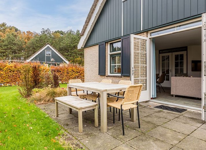 Garten und Nebengebaeude des Bungalows T6B Comfort in De Koog, Texel, umgeben von viel Gruen und rustikalem Charme auf den Watteninseln.