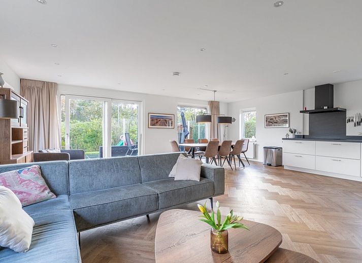 Front view of Stappeland 197, a vacation home in De Koog, Texel with stone facade and garden.