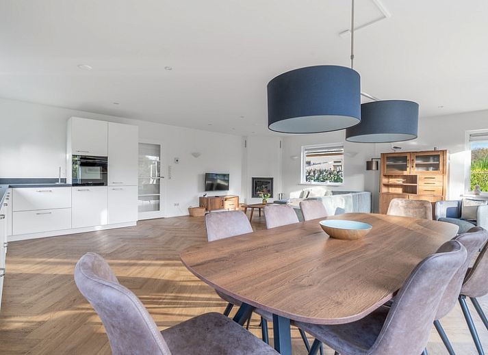 Front view of Stappeland 197, a vacation home in De Koog, Texel with stone facade and garden.