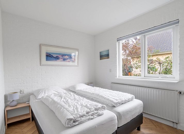 Front view of Stappeland 197, a vacation home in De Koog, Texel with stone facade and garden.