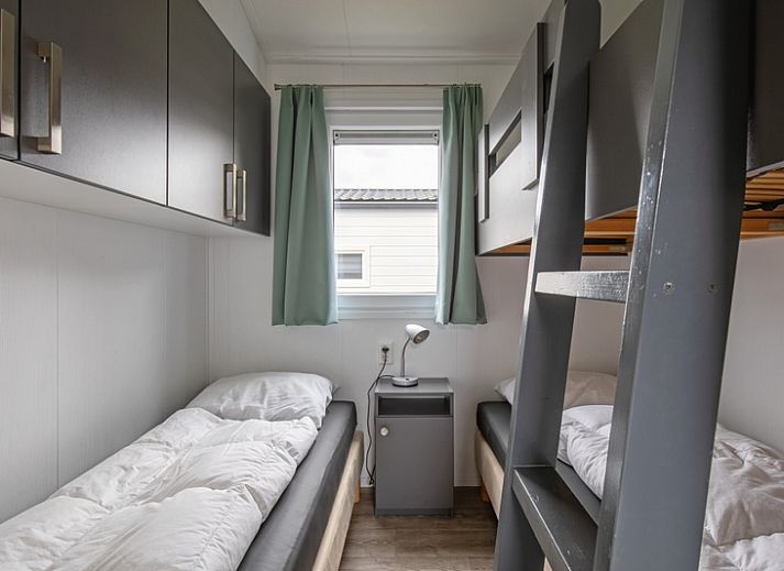 Sunny front view of Chalet Bregkoog 12, a vacation home in De Koog, Texel, ideal for a relaxing stay.