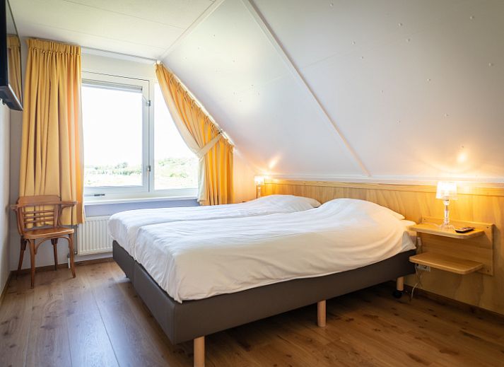 Modernes Wohnzimmer der Villa fuer 4 Personen in De Koog, Texel mit bequemen Sitzgelegenheiten, perfekt fuer ein Ferienhaus auf den Watteninseln.
