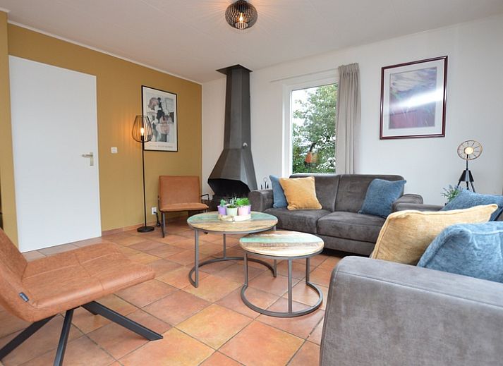 Ferienhaus Stappeland 169 in De Koog Texel mit gruenem Zaun und Sonnenkollektoren.