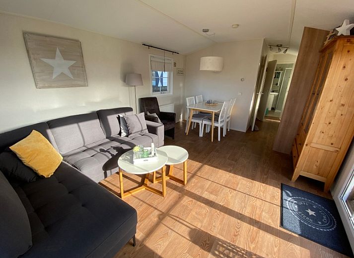 Chalet Bregkoog 255 in De Koog, Texel with sunny veranda and wooden fence, ideal for a relaxing vacation on the Wadden Islands.