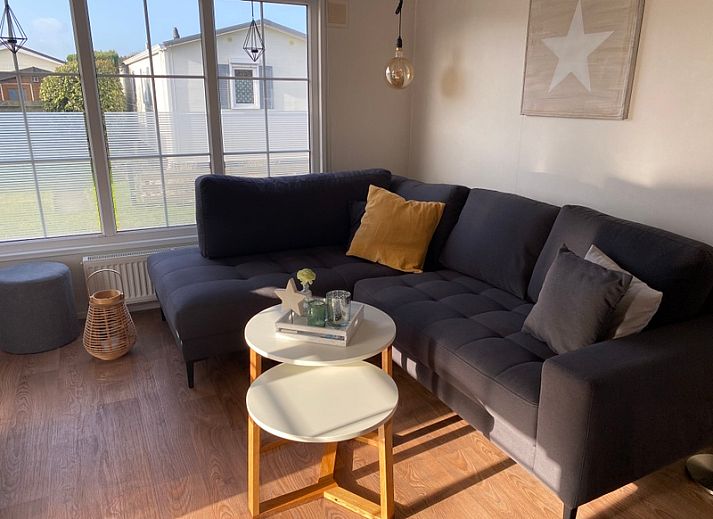 Chalet Bregkoog 255 in De Koog, Texel with sunny veranda and wooden fence, ideal for a relaxing vacation on the Wadden Islands.