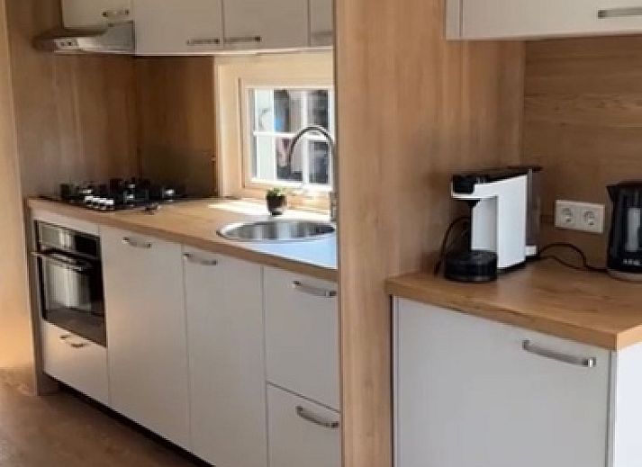 Vacation home Chalet Bregkoog 255 in De Koog, Texel with spacious garden and wooden fence, perfect for a relaxing vacation on the Wadden Islands.