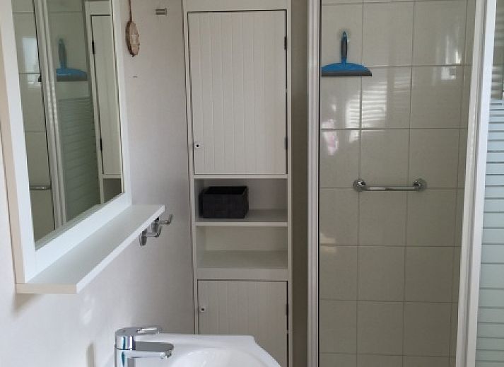 Vacation home Chalet Bregkoog 255 in De Koog, Texel with spacious garden and wooden fence, perfect for a relaxing vacation on the Wadden Islands.