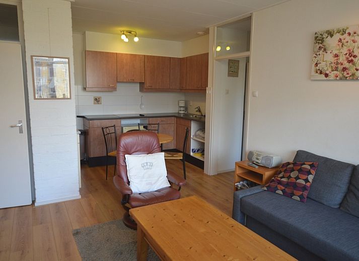 Cozy living room in Apartment Kerckeland 50, De Koog, Texel with comfortable seating area and bookshelves.