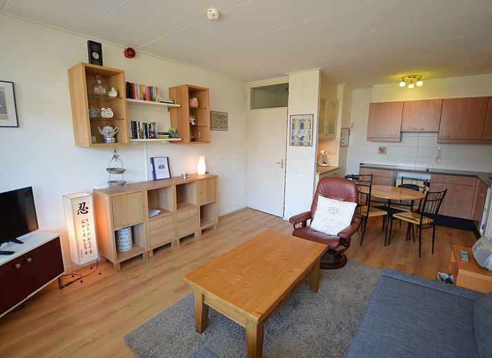 Cozy living room in Apartment Kerckeland 50, De Koog, Texel with comfortable seating area and bookshelves.