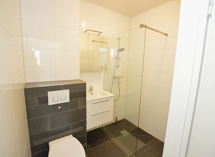 Bright living room of Apartment Kerckeland 50, De Koog, Texel with large windows and an inviting sofa.