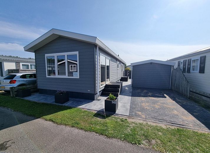 Cozy living room in Chaletpark Bregkoog - Chalet 240 De Texelse Berg, De Koog, Texel with comfortable sofas and dining area.