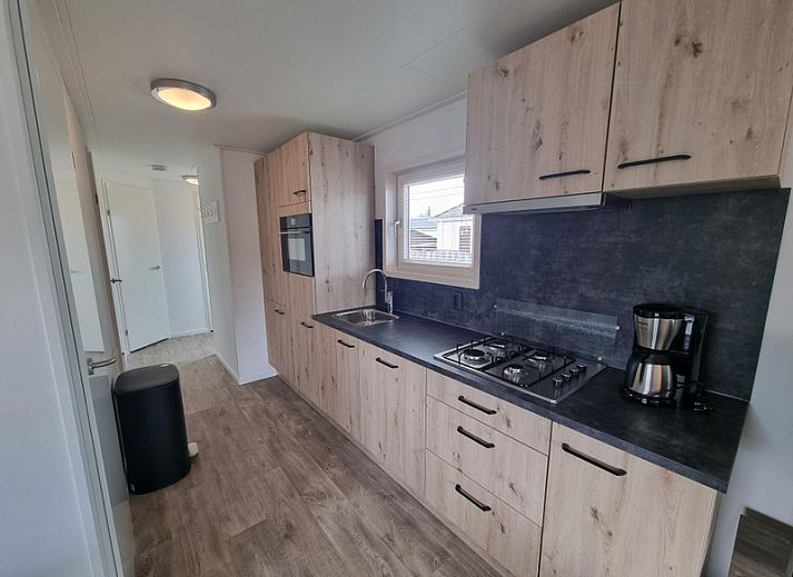 Cozy living room in Chaletpark Bregkoog - Chalet 240 De Texelse Berg, De Koog, Texel with comfortable sofas and dining area.